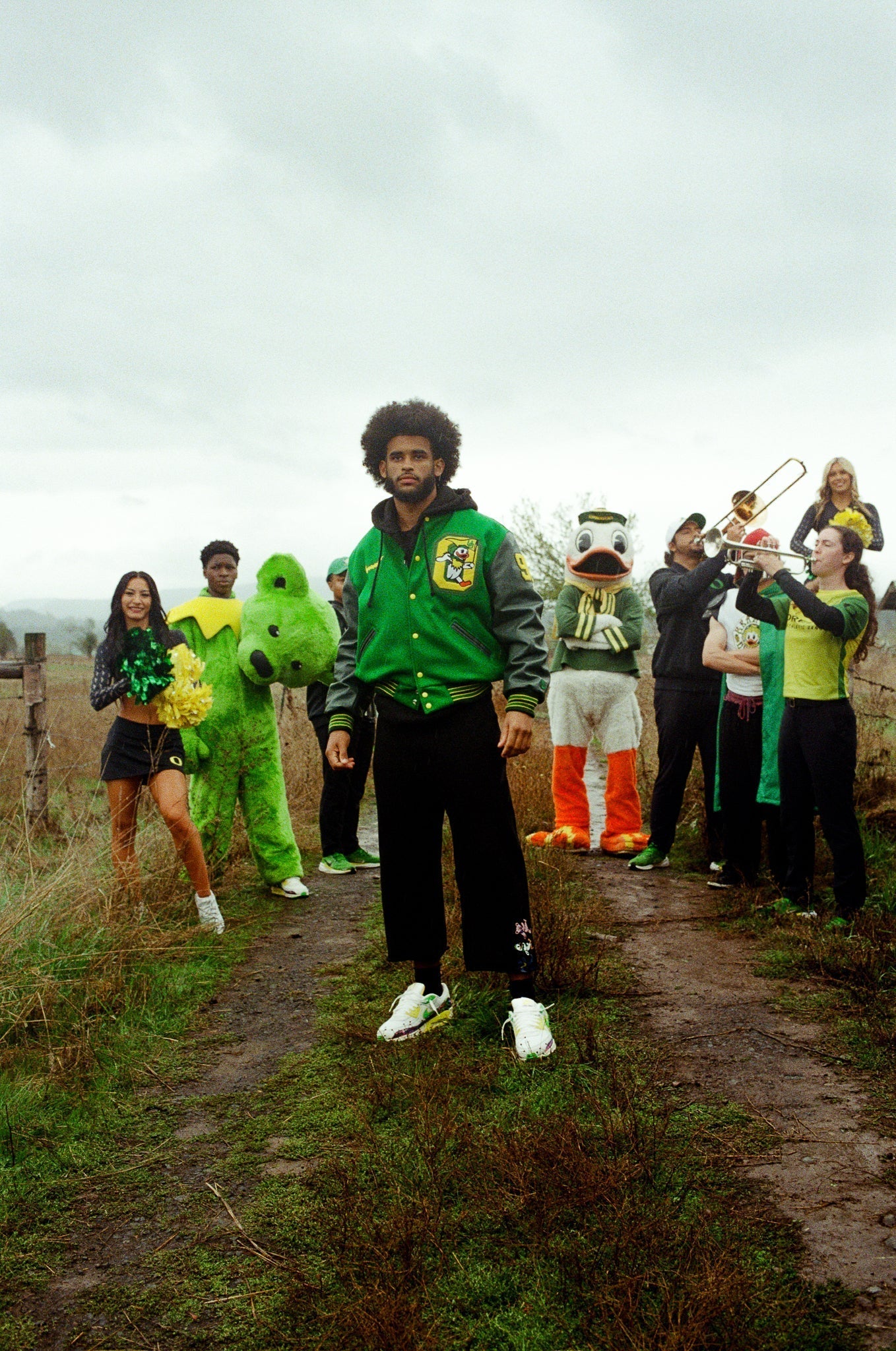 Group in collegiate apparel and mascots on a rural path, showing school spirit. Class Trip | Officially Licensed Collegiate Apparel
