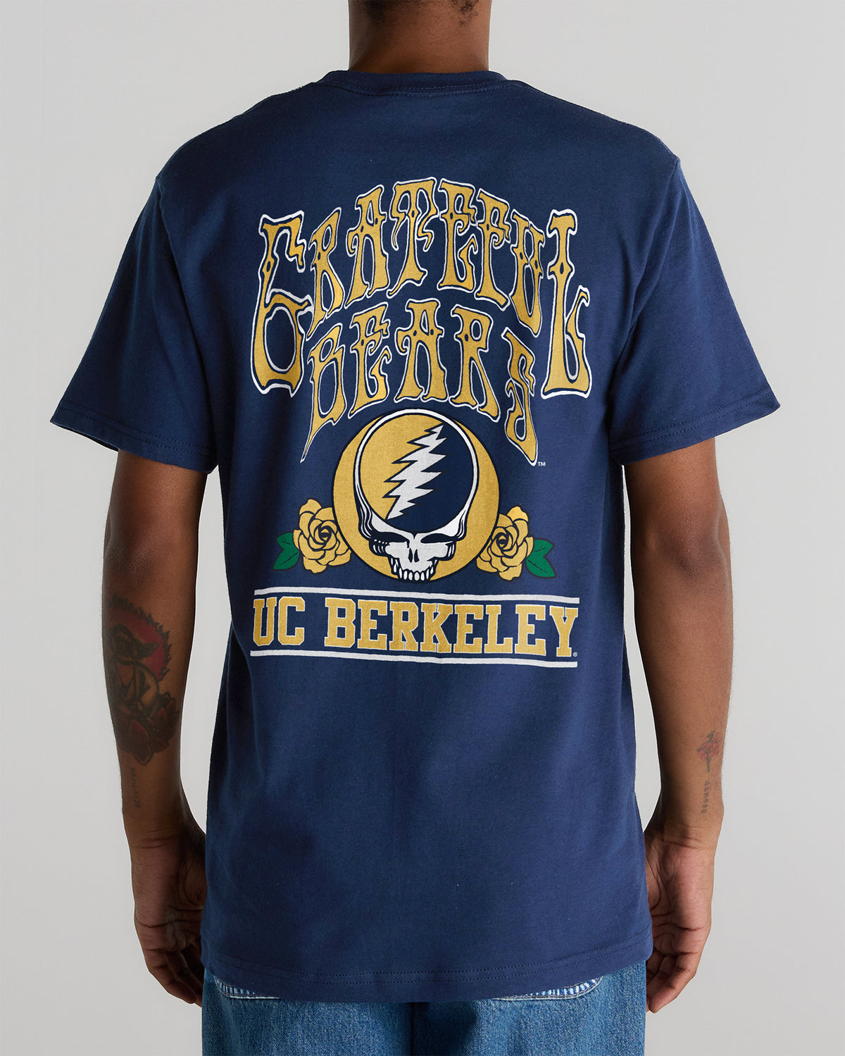 Model wearing the Navy Cal Berkeley x Grateful Dead Berkeley Steal Your Face Tee, back view. Class Trip | Higher Education