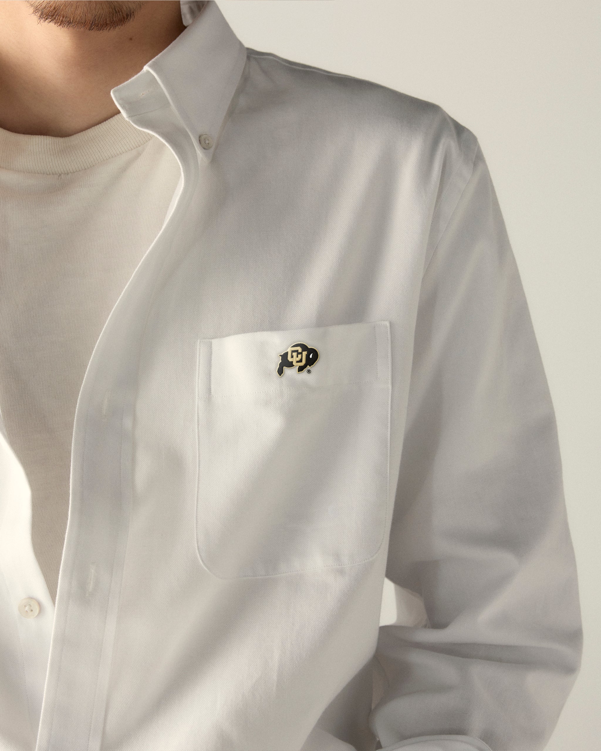 White men's oxford shirt with college logo patch on chest pocket, collegiate apparel. Class Trip | Officially Licensed Collegiate Apparel
