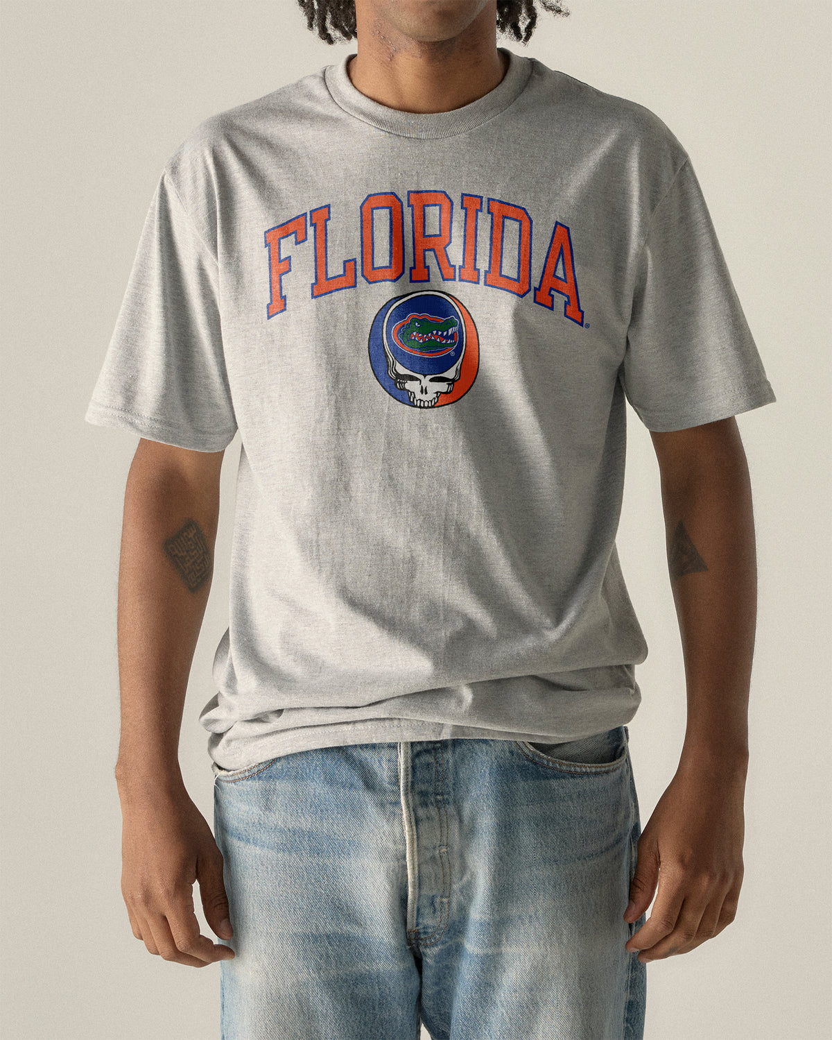 Man wearing a grey Florida x Grateful Dead Steal Your Face Arch Tee. Class Trip | Higher Education