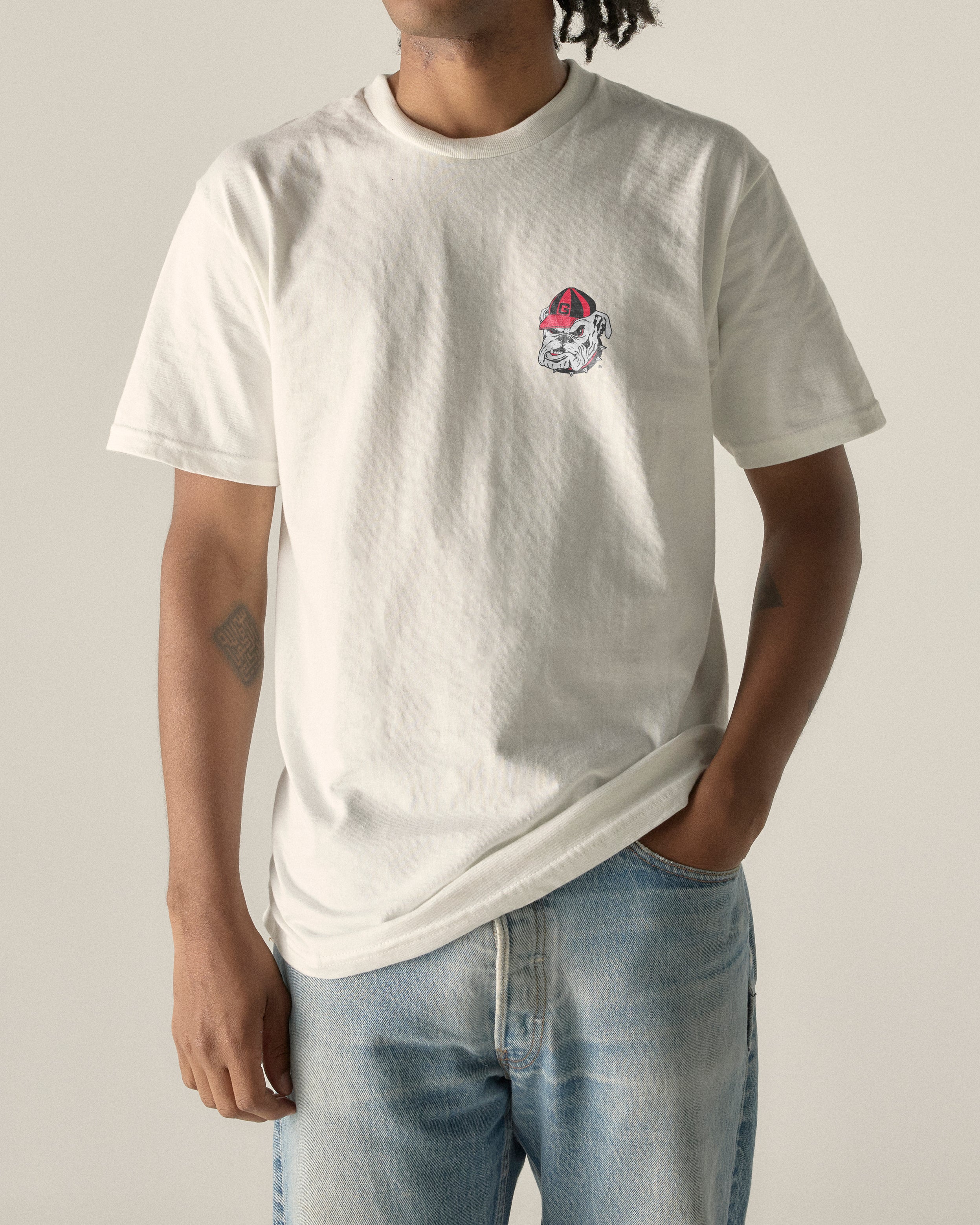 White Georgia Bulldogs logo tee on model, casual collegiate style. Class Trip | Officially Licensed Collegiate Apparel