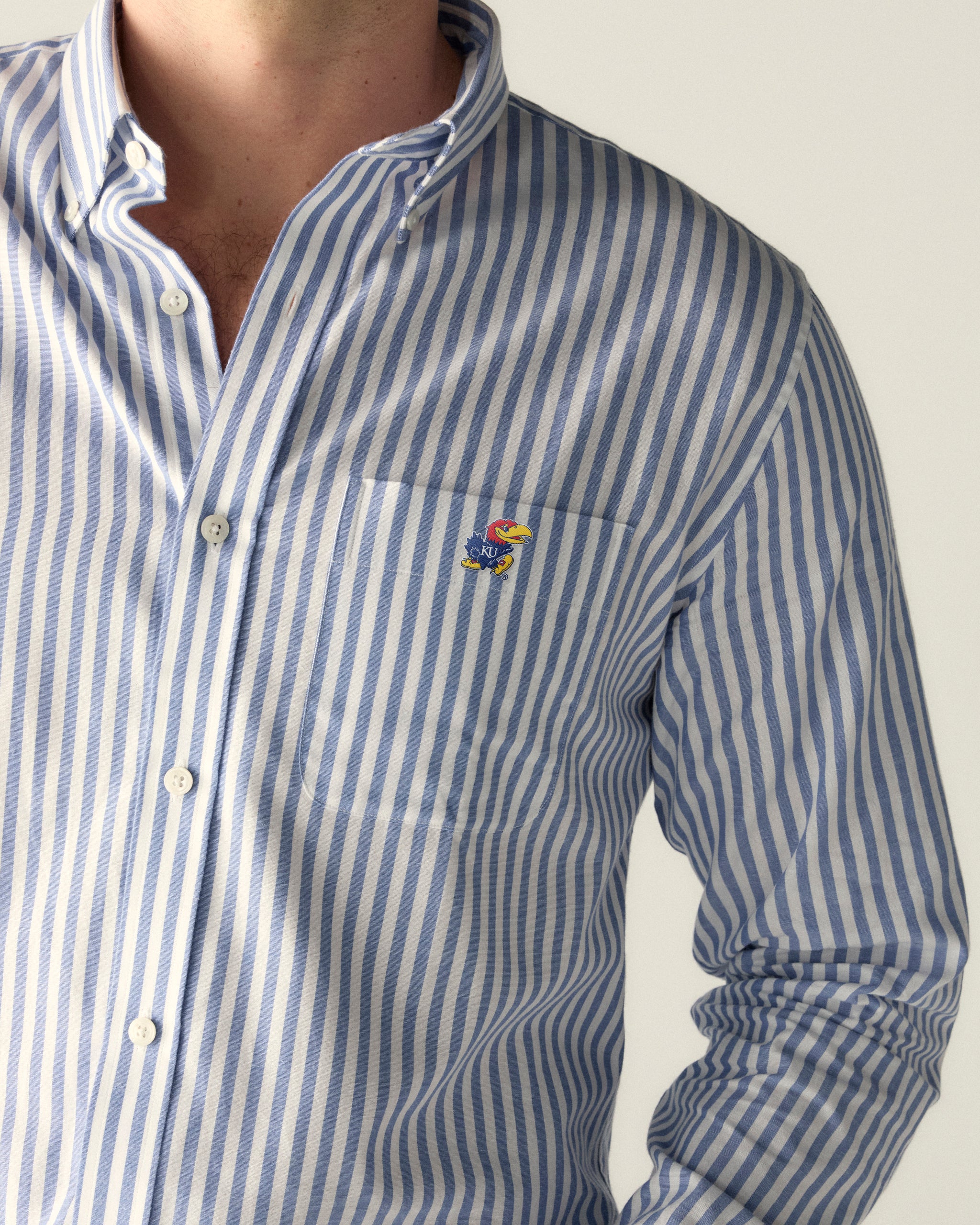 Men's blue and white striped button-down shirt with college logo patch. Class Trip | Officially Licensed Collegiate Apparel