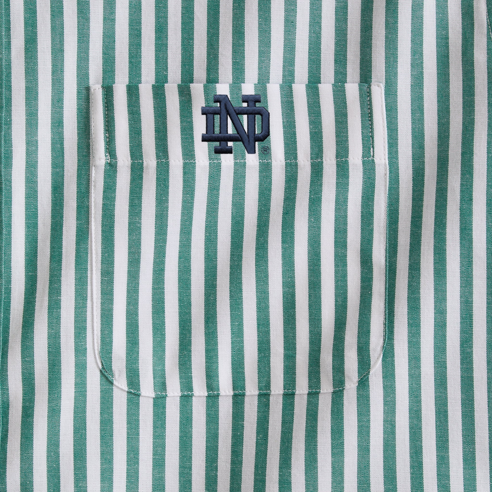 Green and white striped men's shirt pocket with navy college initials embroidery. Class Trip | Officially Licensed Collegiate Apparel