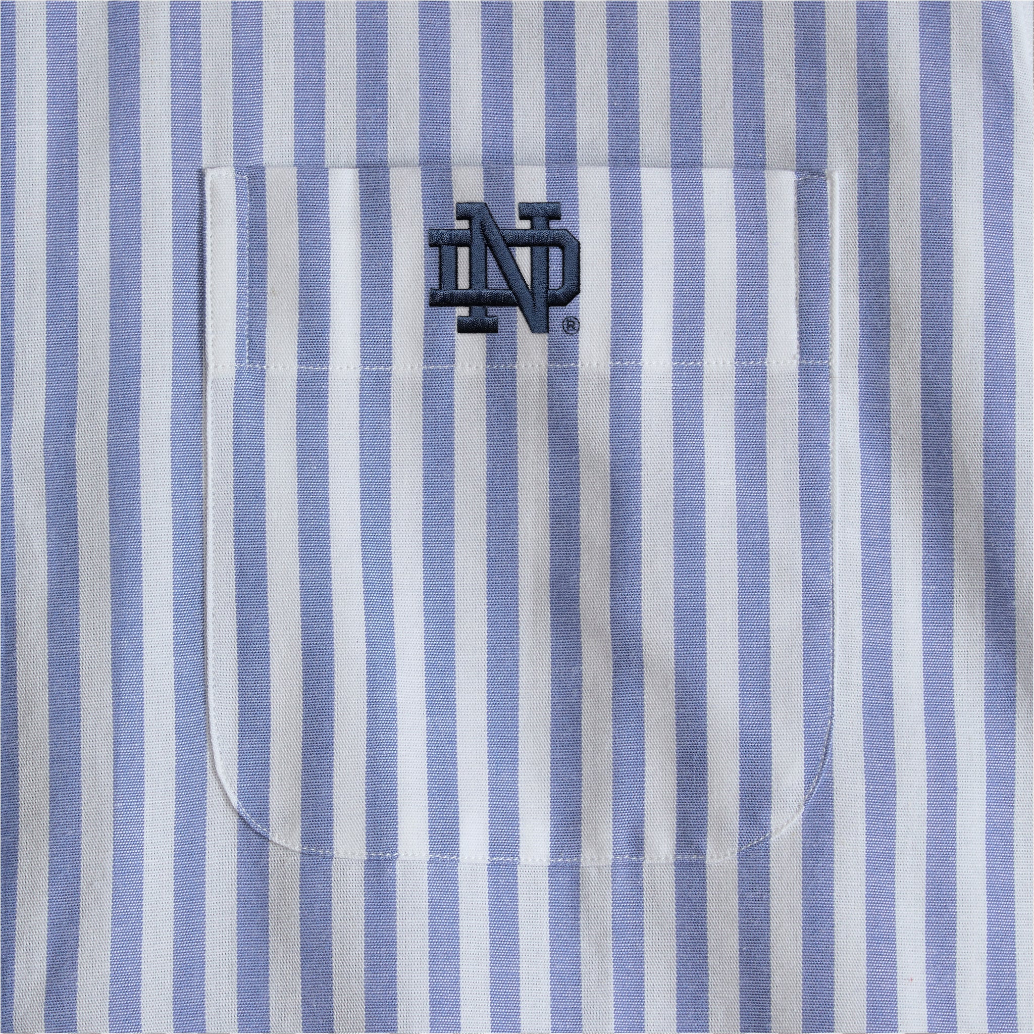 Blue and white striped women's poplin shirt pocket with embroidered collegiate logo. Class Trip | Officially Licensed Collegiate Apparel