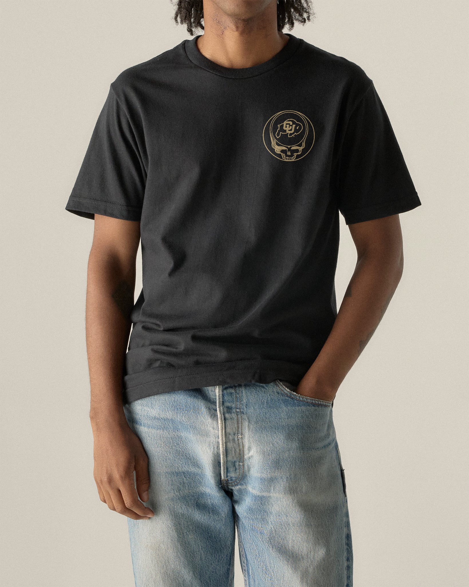 Black t-shirt with gold Grateful Dead skull and CU logo, paired with light denim jeans. Class Trip | Higher Education