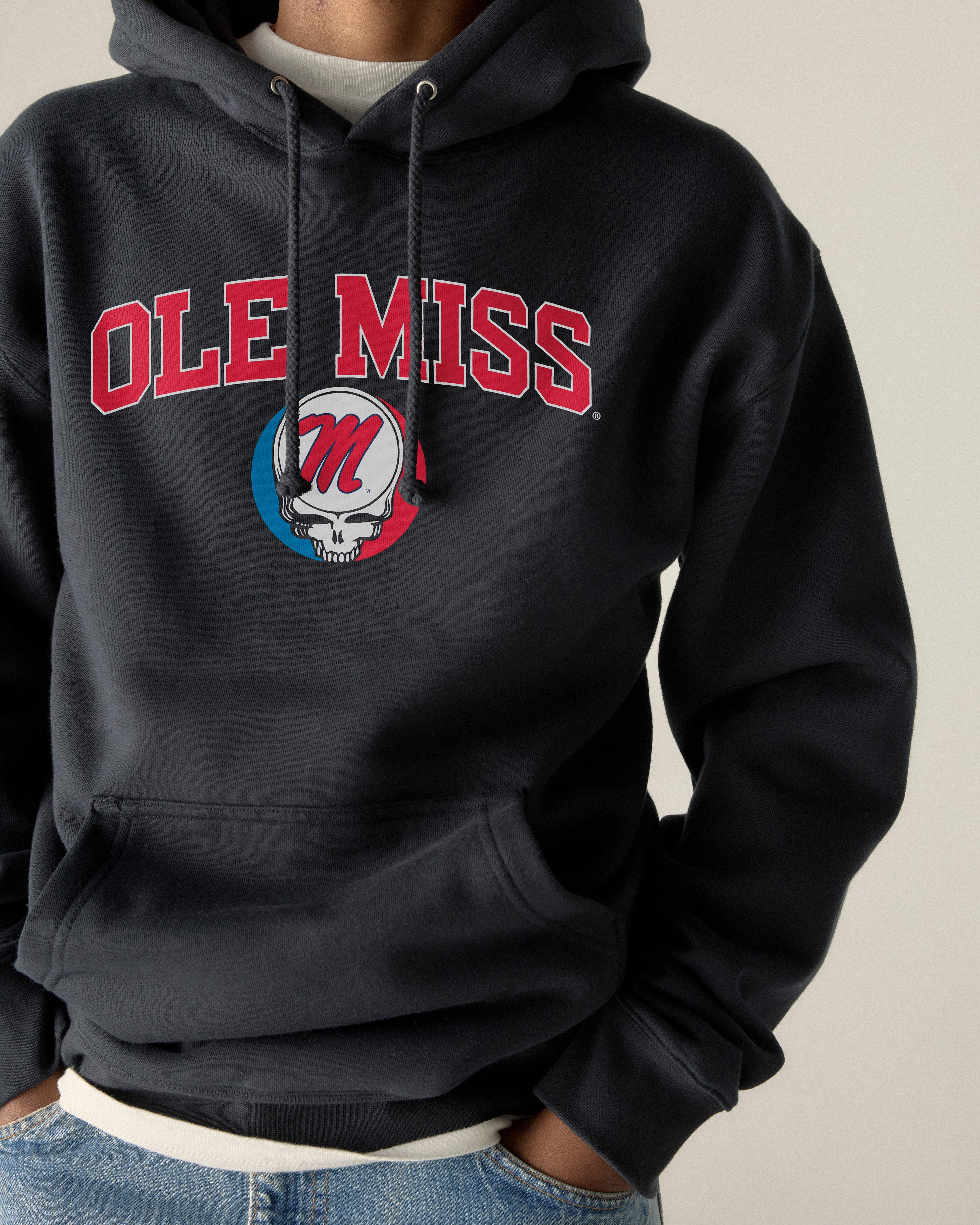 Ole Miss collegiate hoodie with skull graphic, front view on model. Class Trip | Officially Licensed Collegiate Apparel