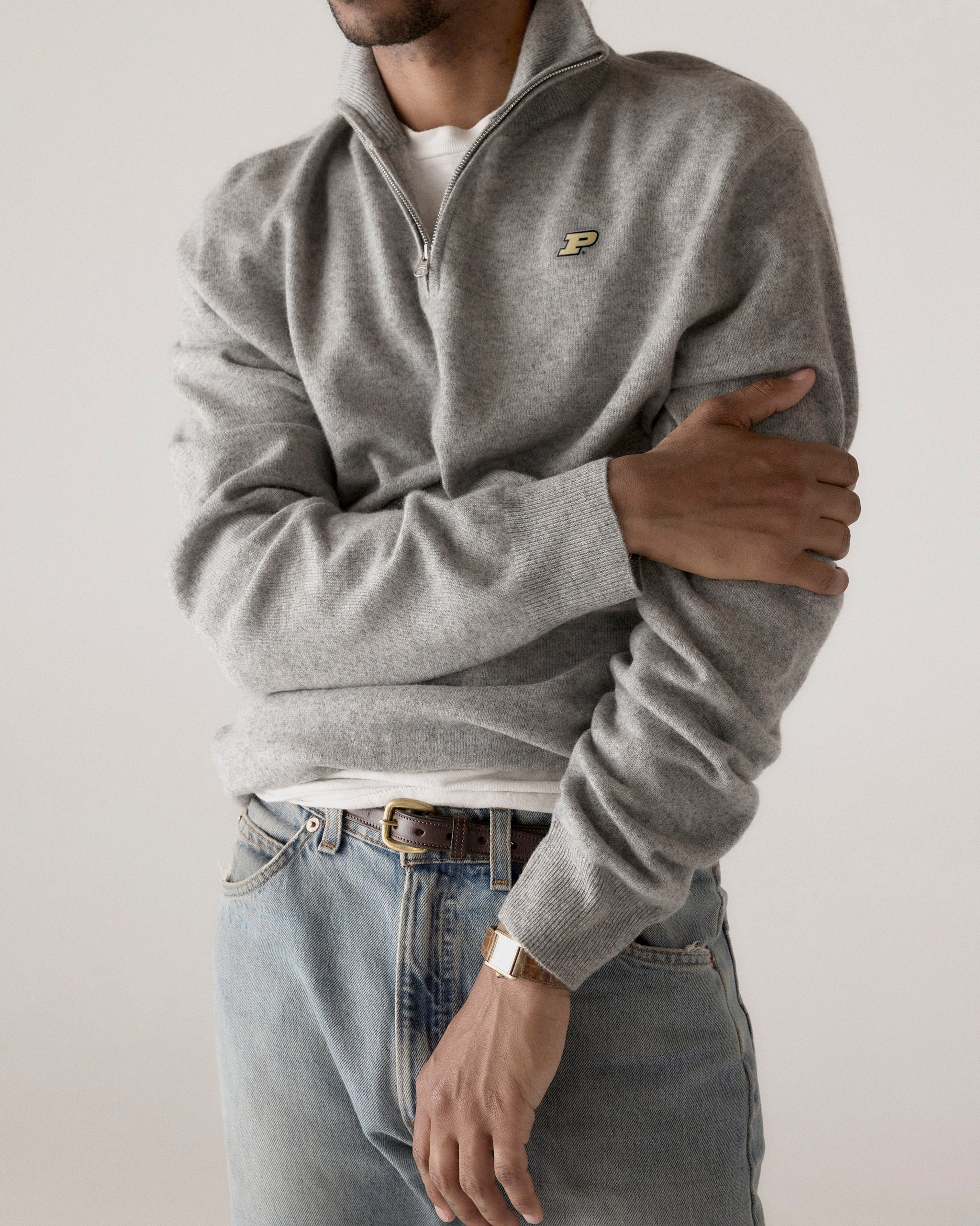 Man wearing grey collegiate quarter zip sweater and jeans, P logo detail, casual style. Class Trip | Officially Licensed Collegiate Apparel