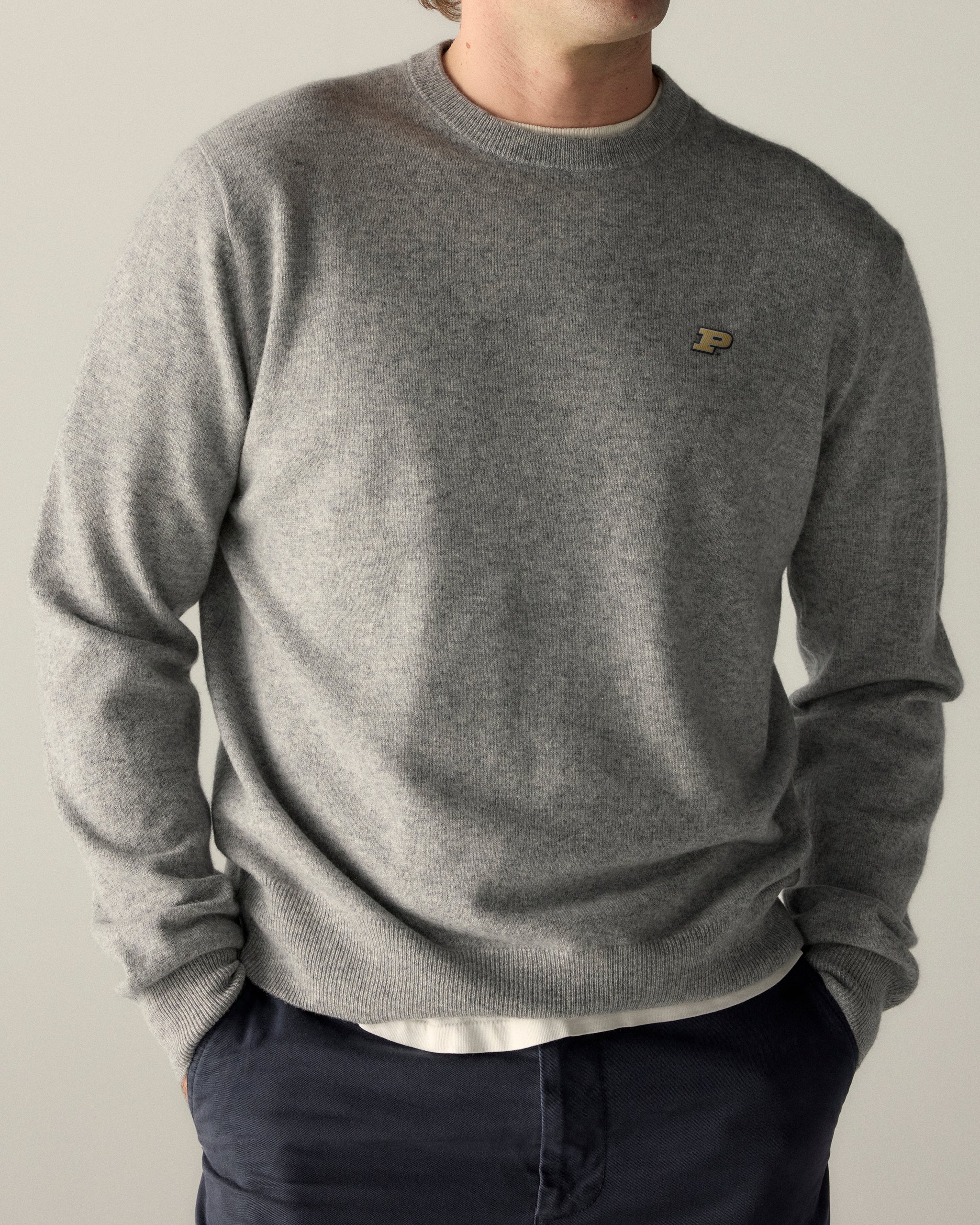 Man wearing grey merino crewneck sweater with collegiate P logo, casual style. Class Trip | Officially Licensed Collegiate Apparel