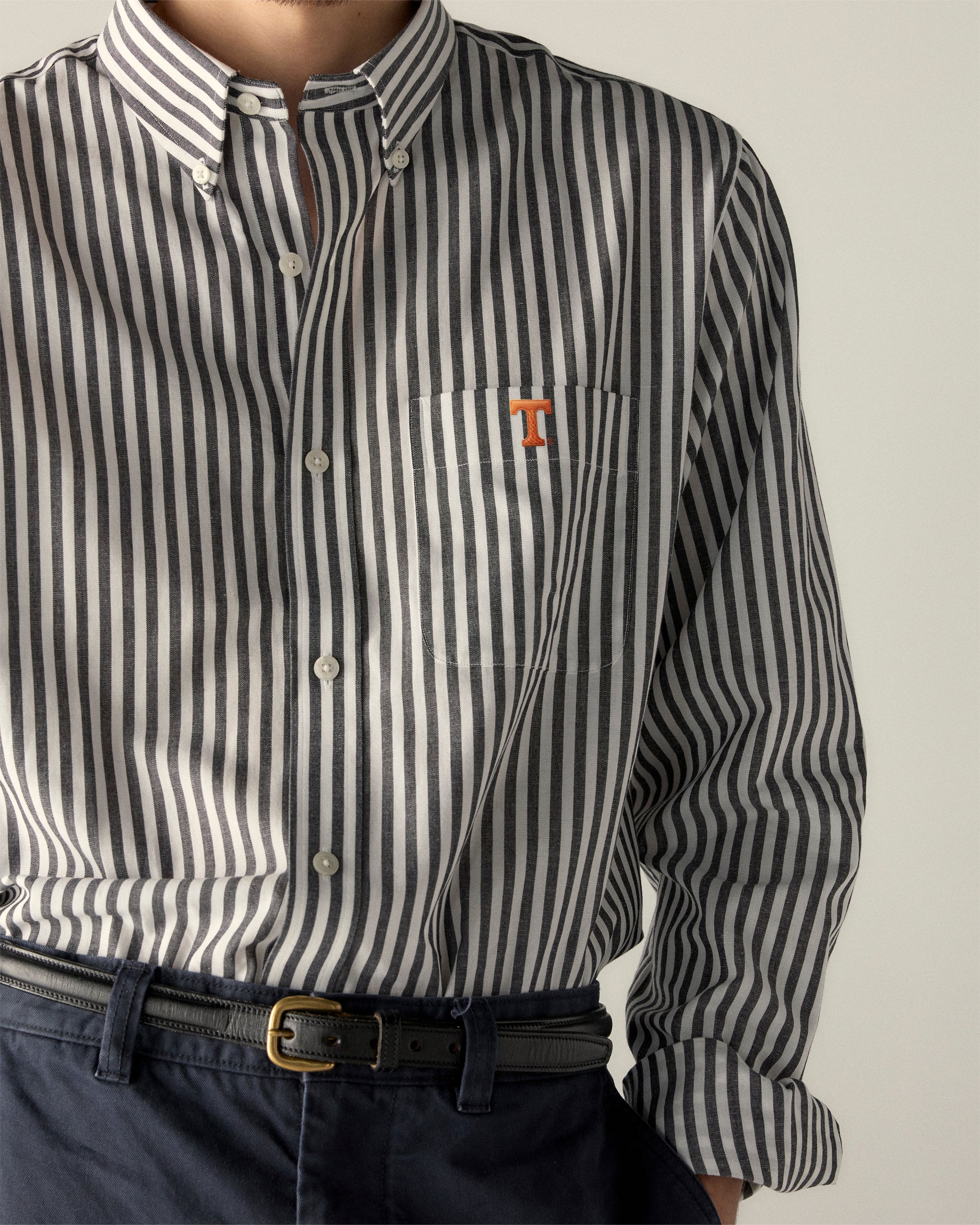 Men's black and white striped button-down shirt with orange collegiate T logo. Class Trip | Officially Licensed Collegiate Apparel