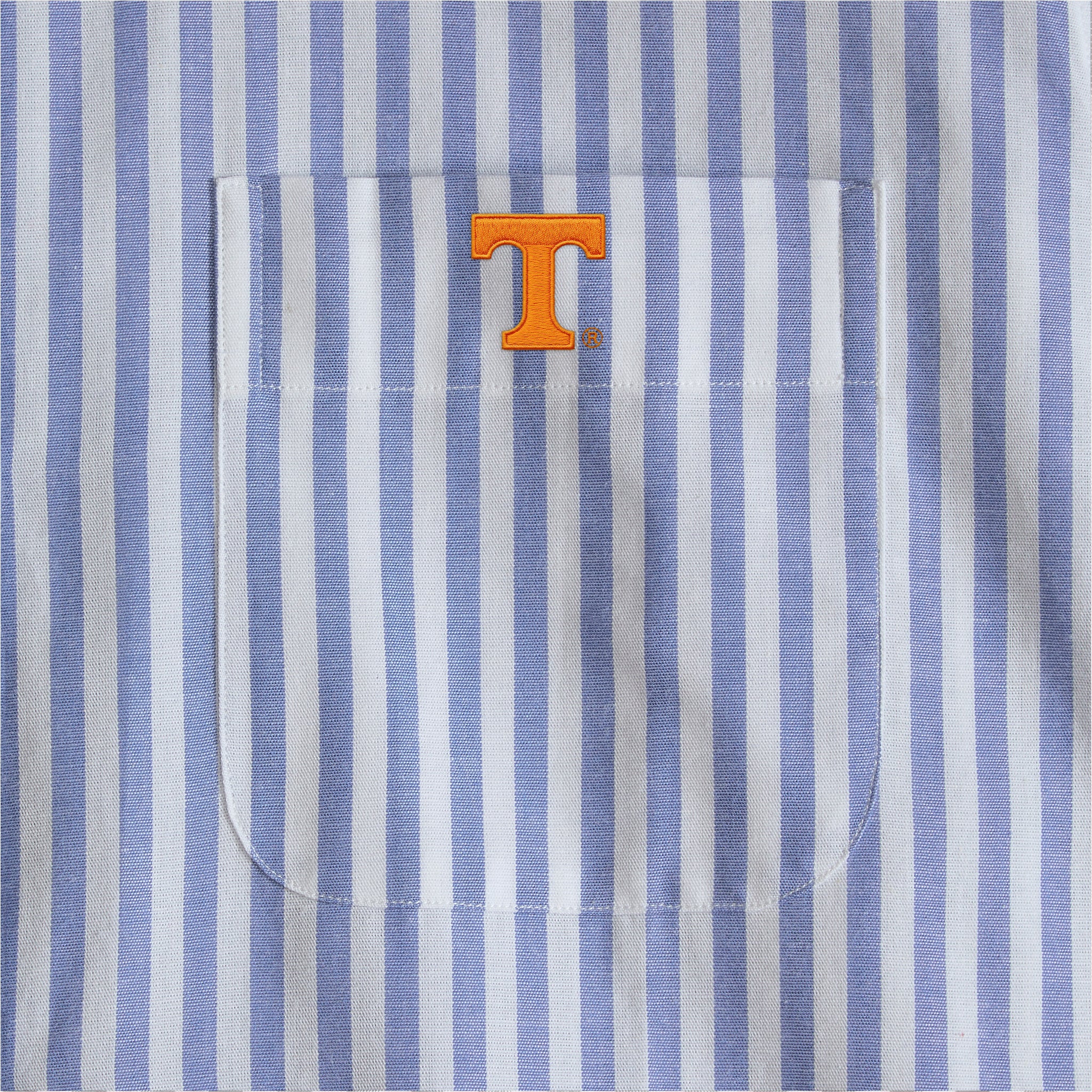 Blue and white striped poplin shirt pocket with orange collegiate T logo, Class Trip | Officially Licensed Collegiate Apparel