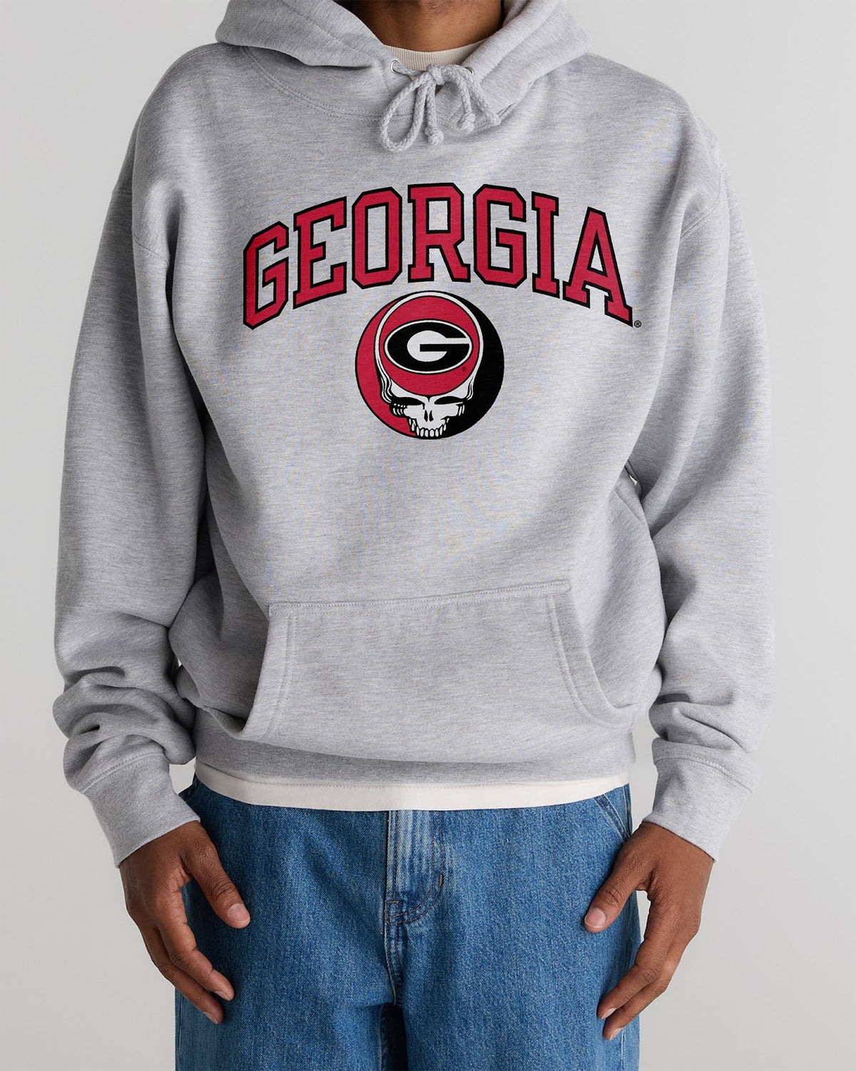 Model wearing the Heather Grey Georgia x Grateful Dead Steal Your Face Arch Hoodie, front view. Class Trip | Higher Education