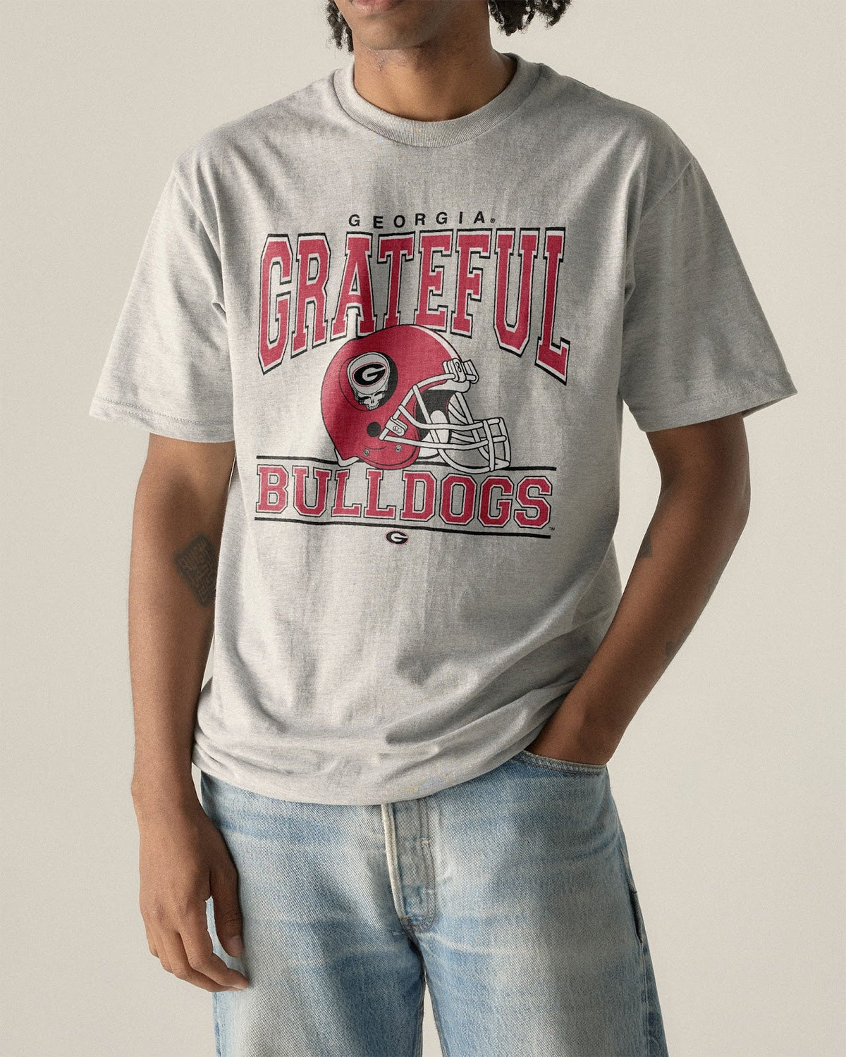 Model wearing the Heather Grey Georgia x Grateful Dead Steal Your Helmet Tee, front view. Class Trip | Higher Education