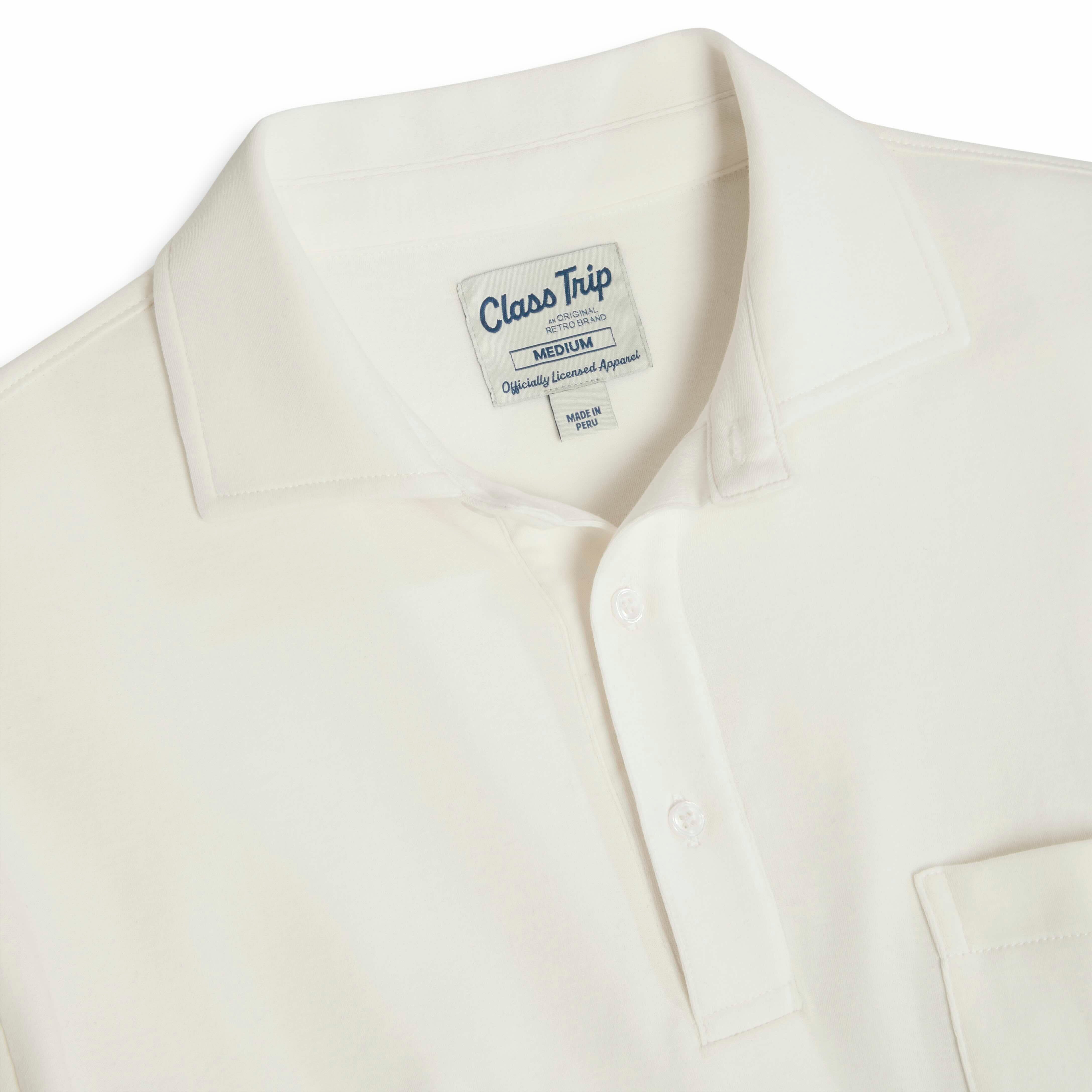 Detail of white collegiate polo shirt with Class Trip label and buttons. Class Trip | Officially Licensed Collegiate Apparel