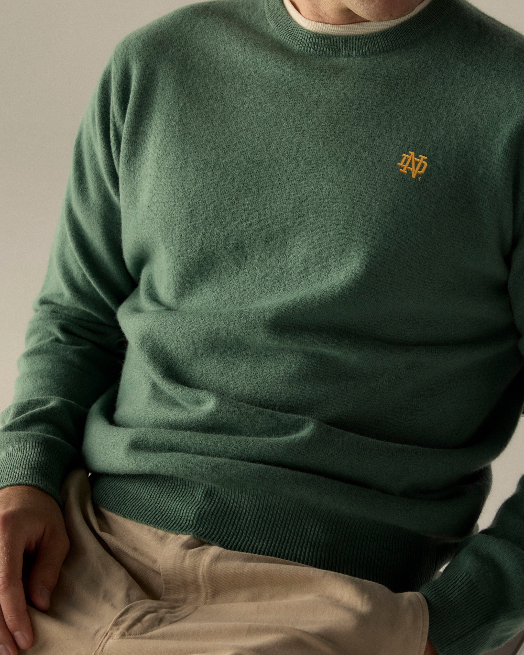 Green crewneck sweater with yellow collegiate logo embroidery, casual fit. Class Trip | Officially Licensed Collegiate Apparel