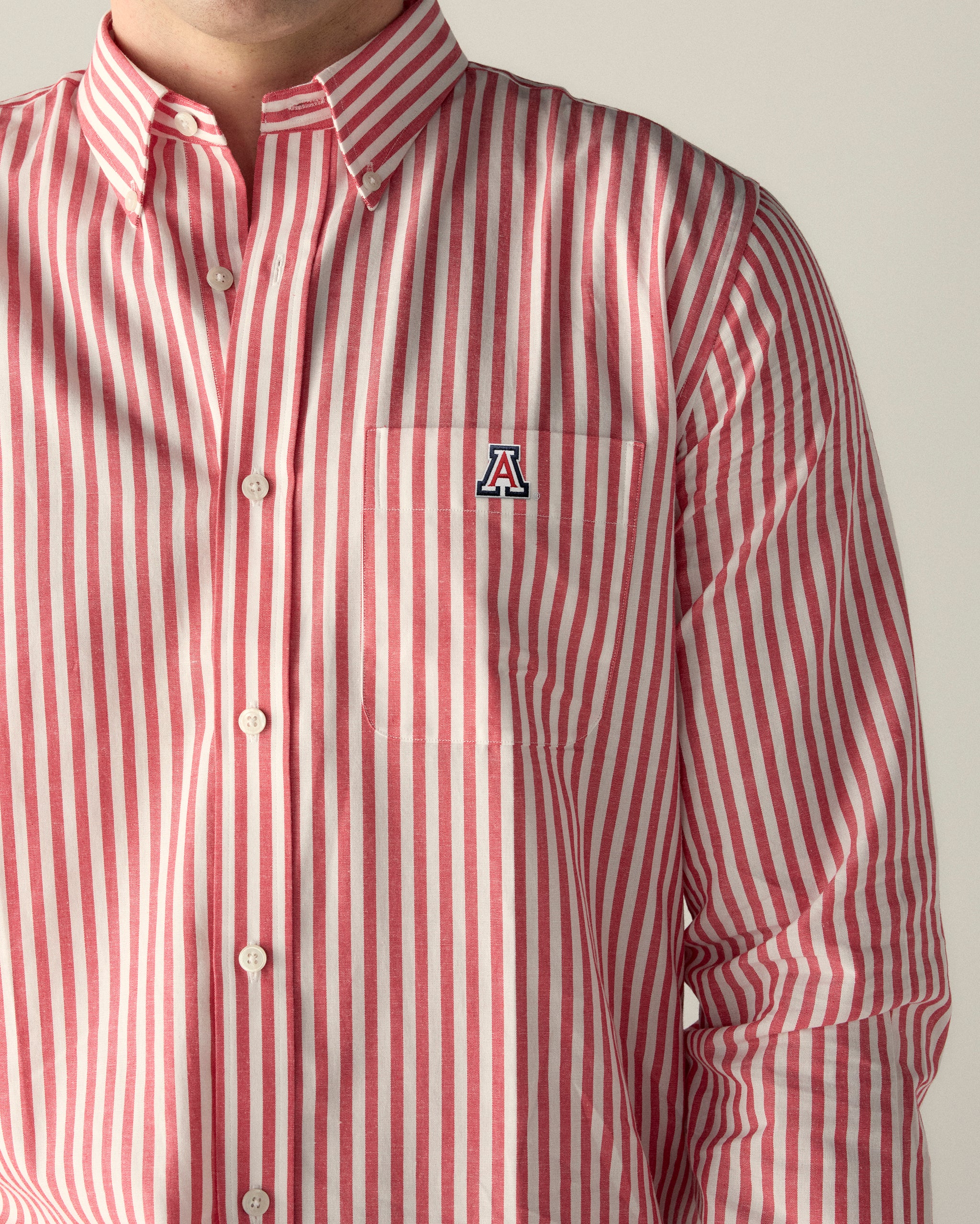 Red and white striped button-down shirt with Arizona 'A' logo on chest pocket. Class Trip | Officially Licensed Collegiate Apparel