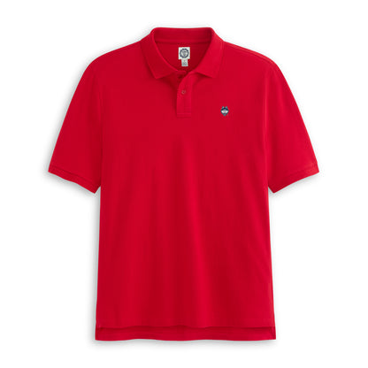Red pique polo shirt with collegiate logo patch on chest, short sleeves, flat lay. Class Trip | Officially Licensed Collegiate Apparel