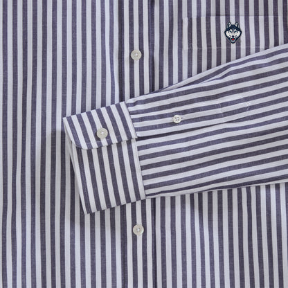 Close-up of navy striped poplin shirt with embroidered husky logo on pocket, white buttons. Class Trip | Officially Licensed Collegiate Apparel