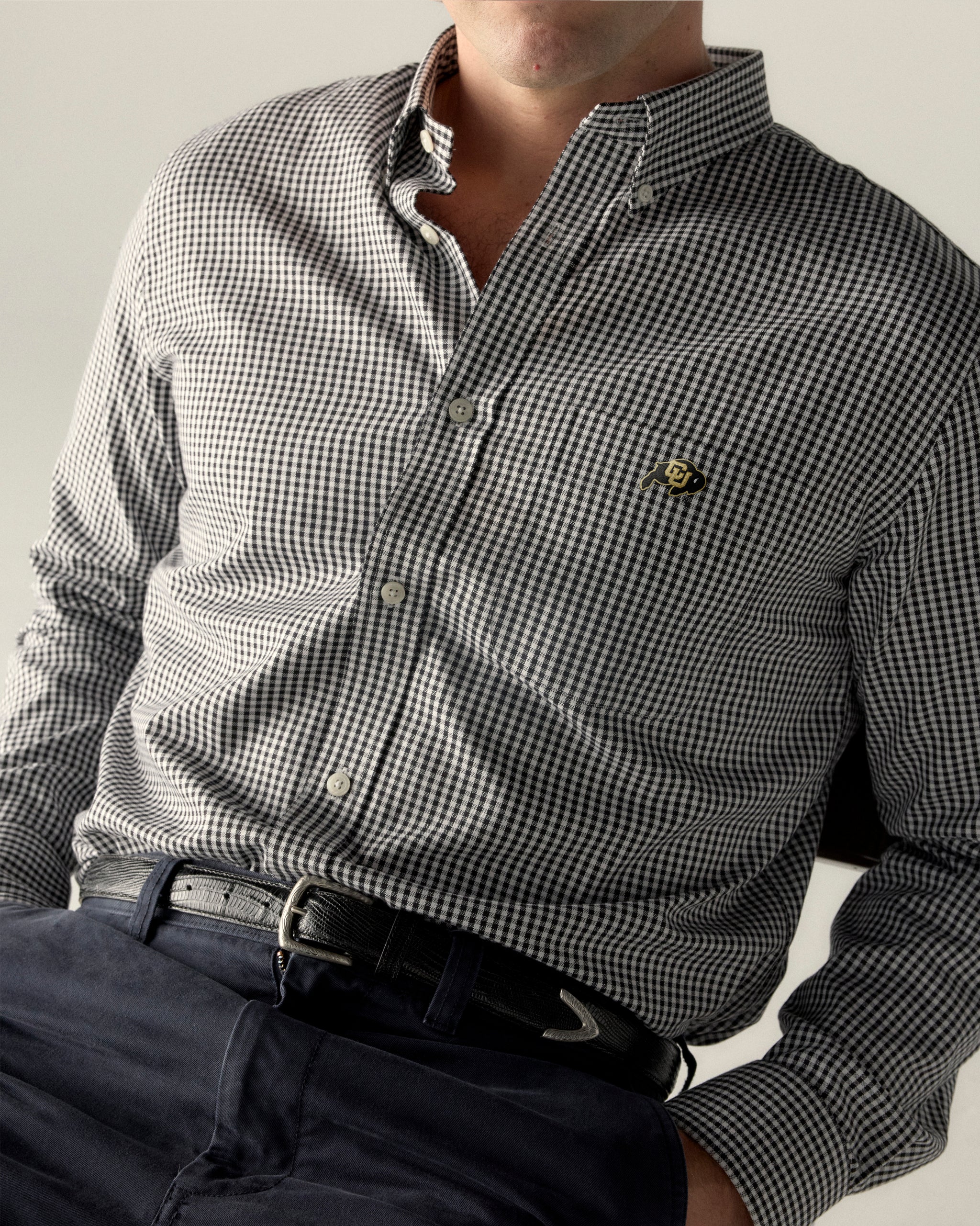 Men's black checkered Oxford shirt with collegiate logo and navy pants. Class Trip | Officially Licensed Collegiate Apparel
