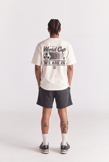 Cream FIFA World Cup graphic tee with 'WE ARE 26' print, worn with dark shorts. Class Trip | Higher Education