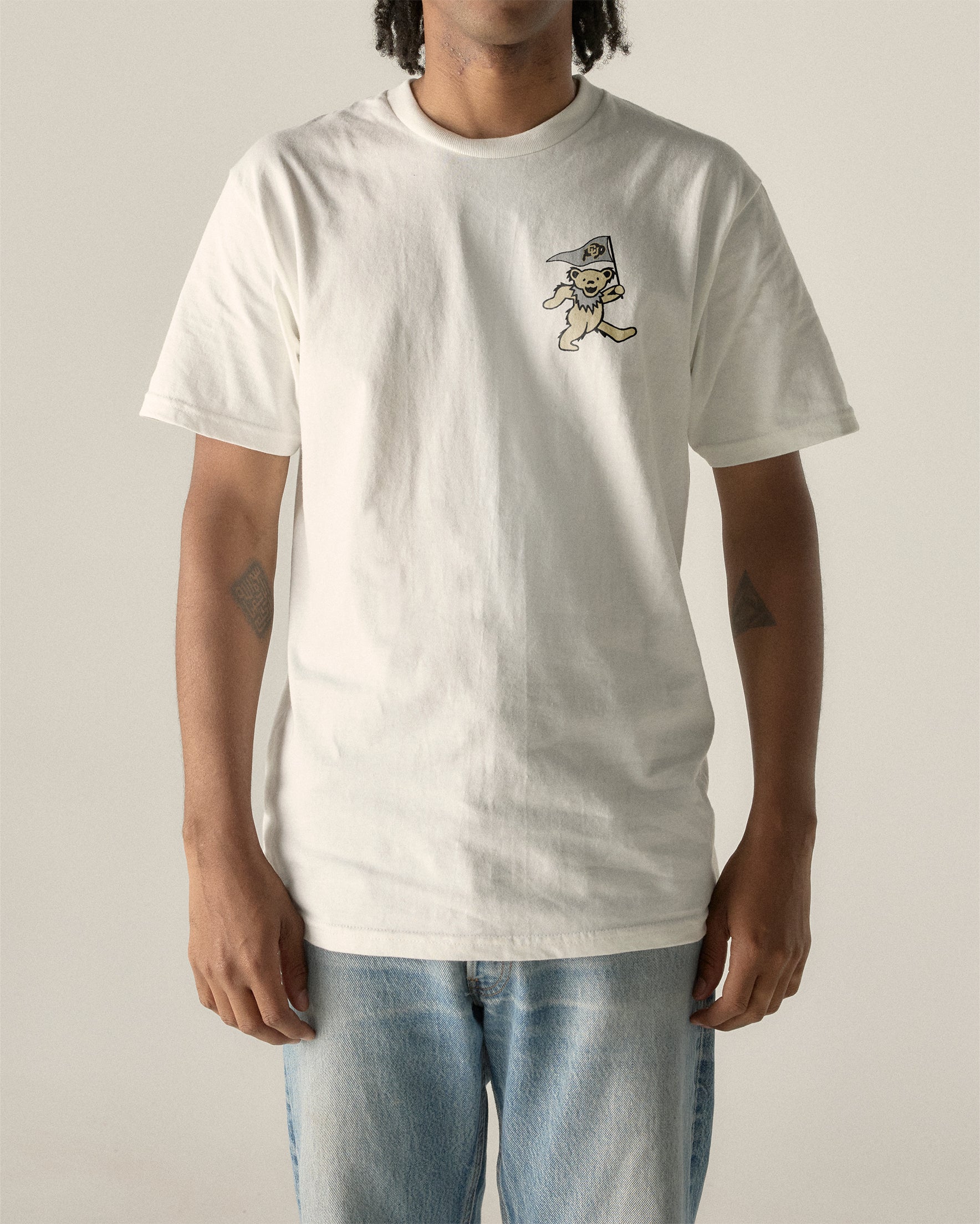 White t-shirt with bear holding flag graphic, casual collegiate style. Class Trip | Higher Education