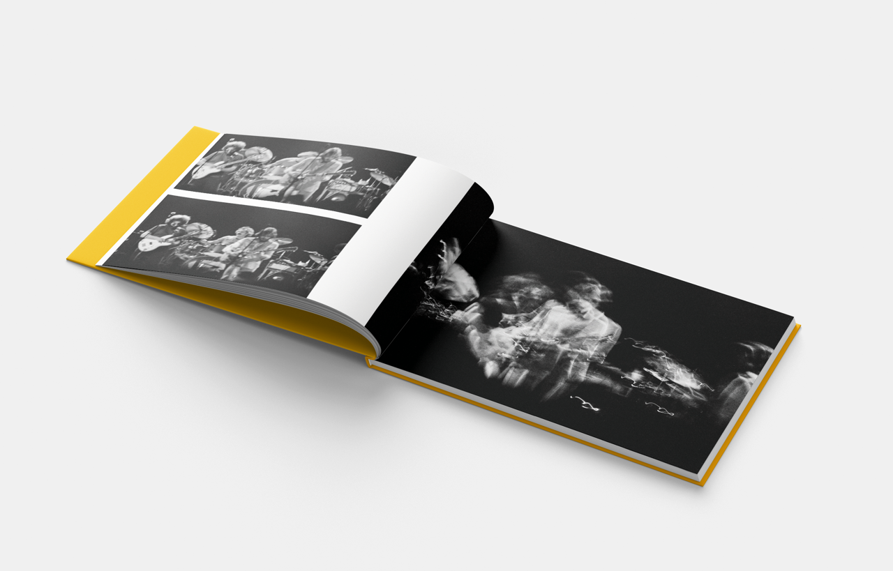 Open photo book with black-and-white band performance images, yellow cover. Class Trip | Officially Licensed Collegiate Apparel