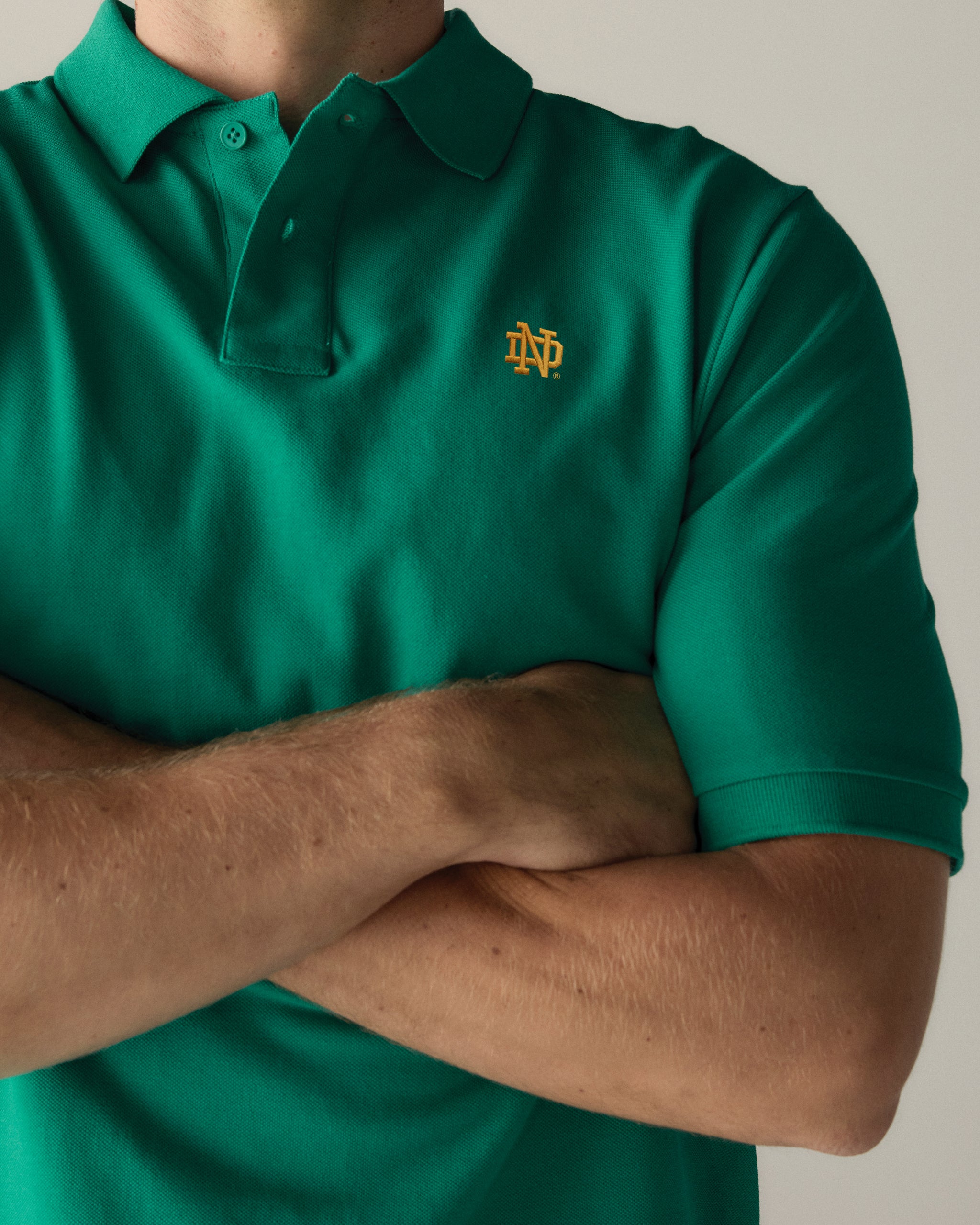 Green pique polo shirt with embroidered ND logo, collegiate apparel. Class Trip | Officially Licensed Collegiate Apparel