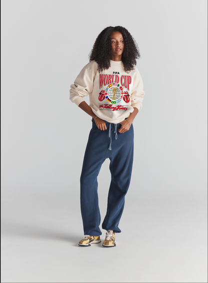 Cream FIFA World Cup x Rolling Stones graphic sweatshirt, navy drawstring pants, retro sneakers. Class Trip | Higher Education