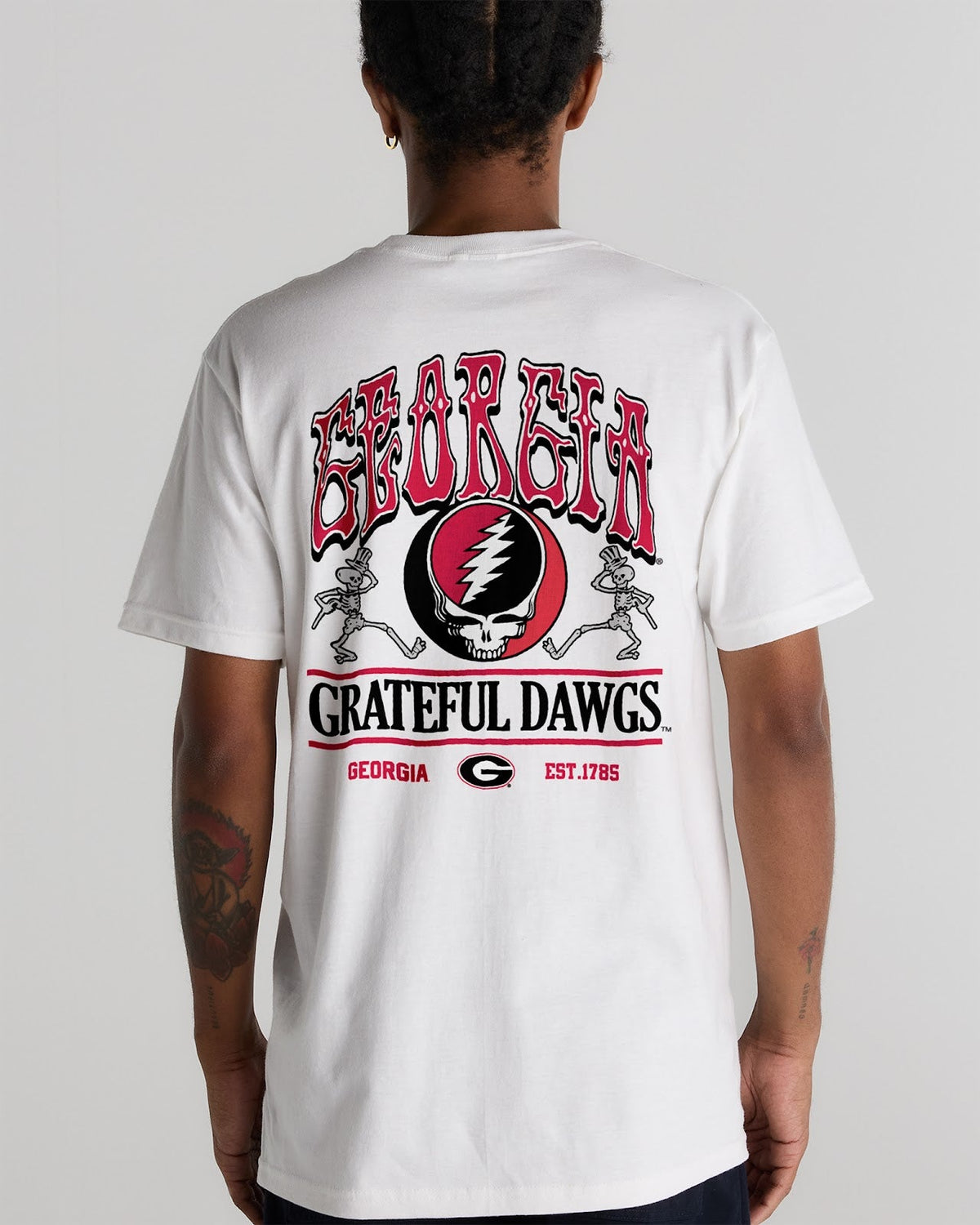 Model wearing the White Georgia x Grateful Dead Shakedown Tee, back view. Class Trip | Higher Education