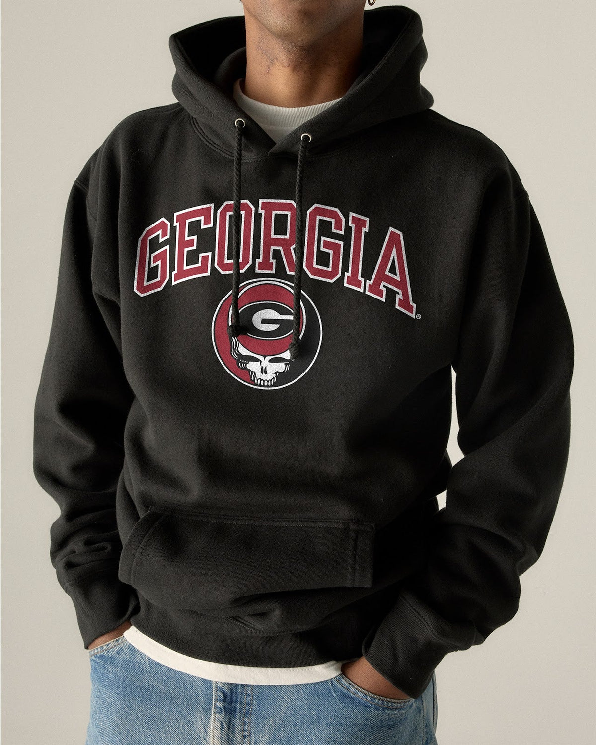 Model wearing the Black Georgia x Grateful Dead Steal Your Face Arch Hoodie, front view. Class Trip | Higher Education