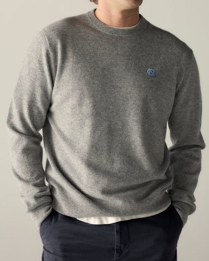 Man wearing grey merino wool crewneck sweater with UNC logo, casual collegiate style. Class Trip | Officially Licensed Collegiate Apparel
