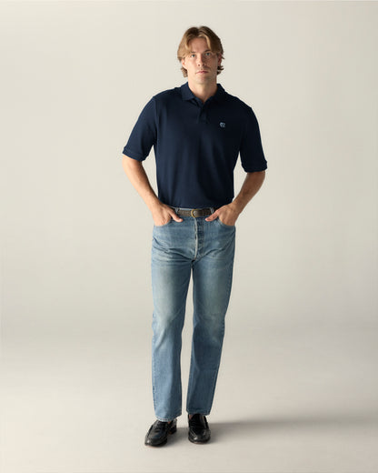 Navy blue UNC polo shirt with light blue logo, paired with jeans and loafers. Class Trip | Officially Licensed Collegiate Apparel